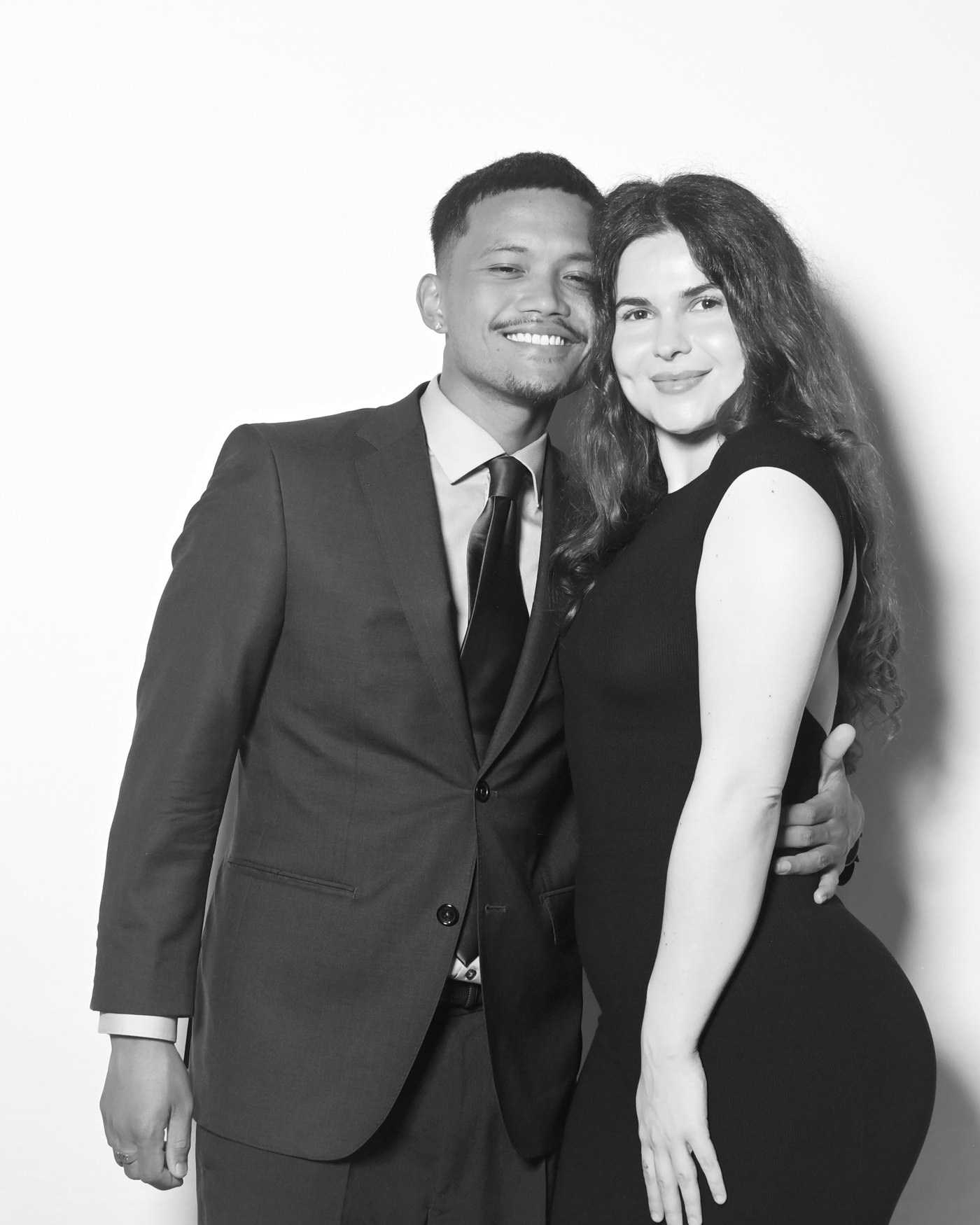 Couple embracing, black and white studio portrait